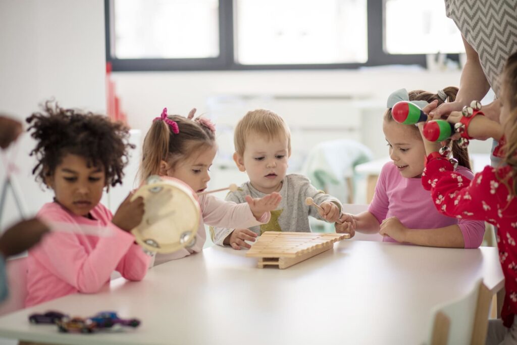 Toddlers playing with musical instruments at a table